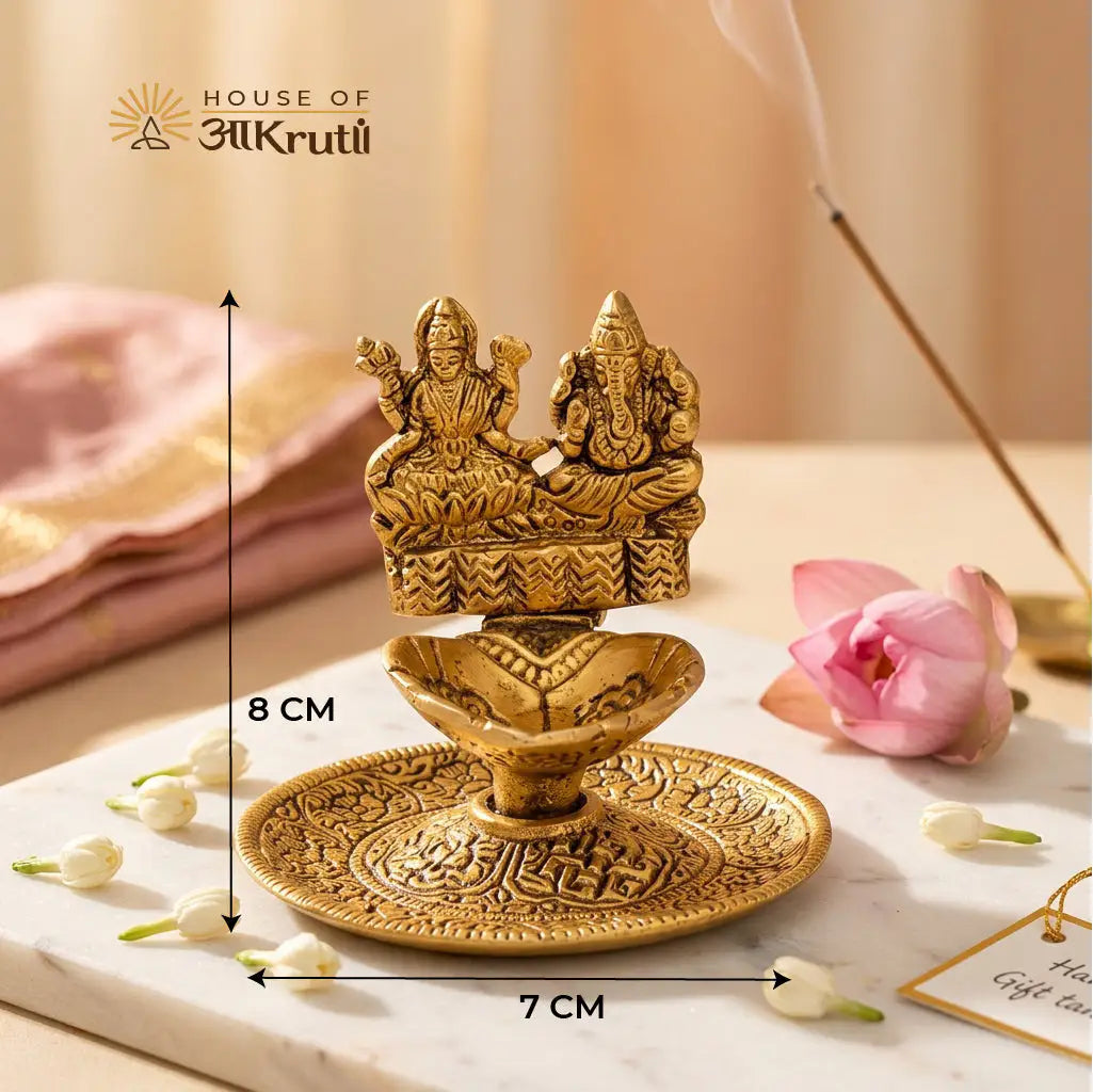Decorative gold statue with measurements on a marble surface with flowers and a pink cloth.